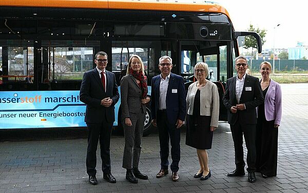 Vor einem Brennstoffzellenbus stehen Staatssekretär Höppner, Ministerin Walker und Beteiligte der MRN und e-mobil BW