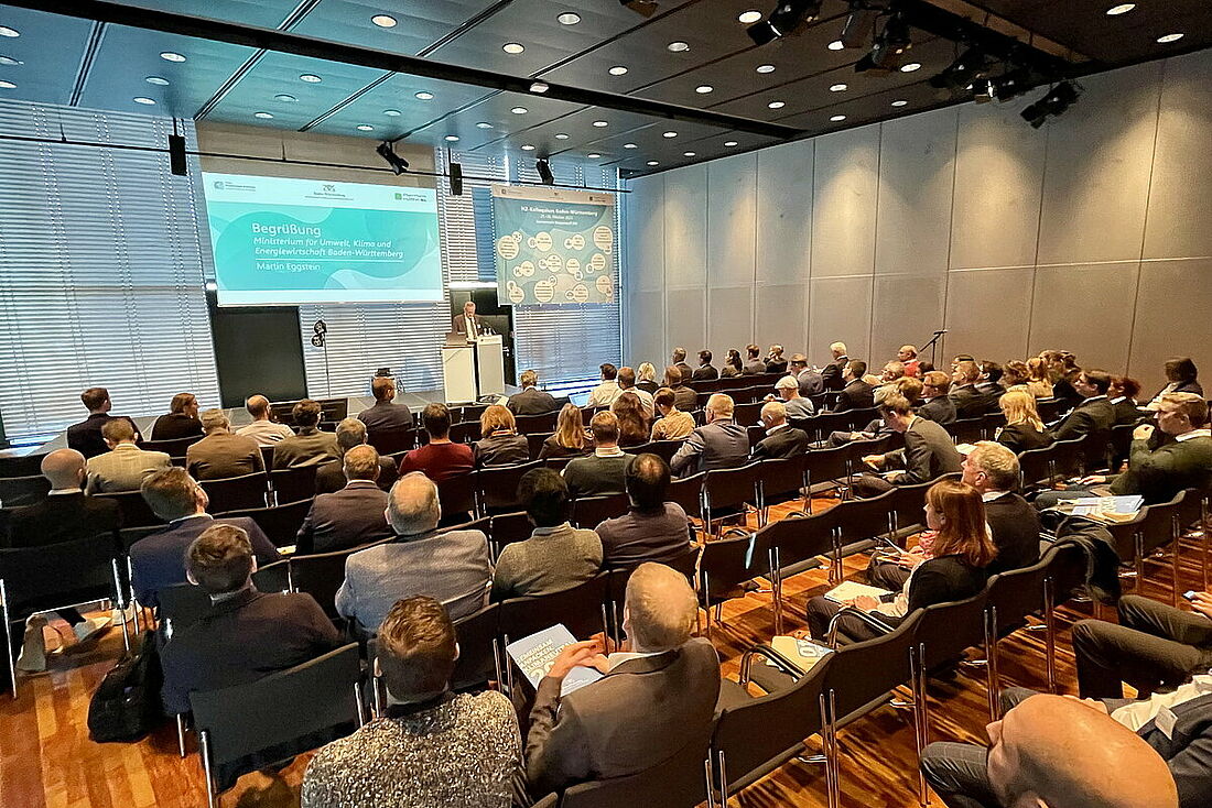 Symbolbild eines Publikums, das in einem Konferenzraum sitzt und einem Vortrag zuhört.