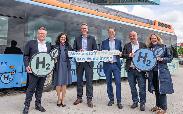 Landrat und Oberbürgermeister posieren mit weiteren Verantwortlichen vor zwei Wasserstoffbussen