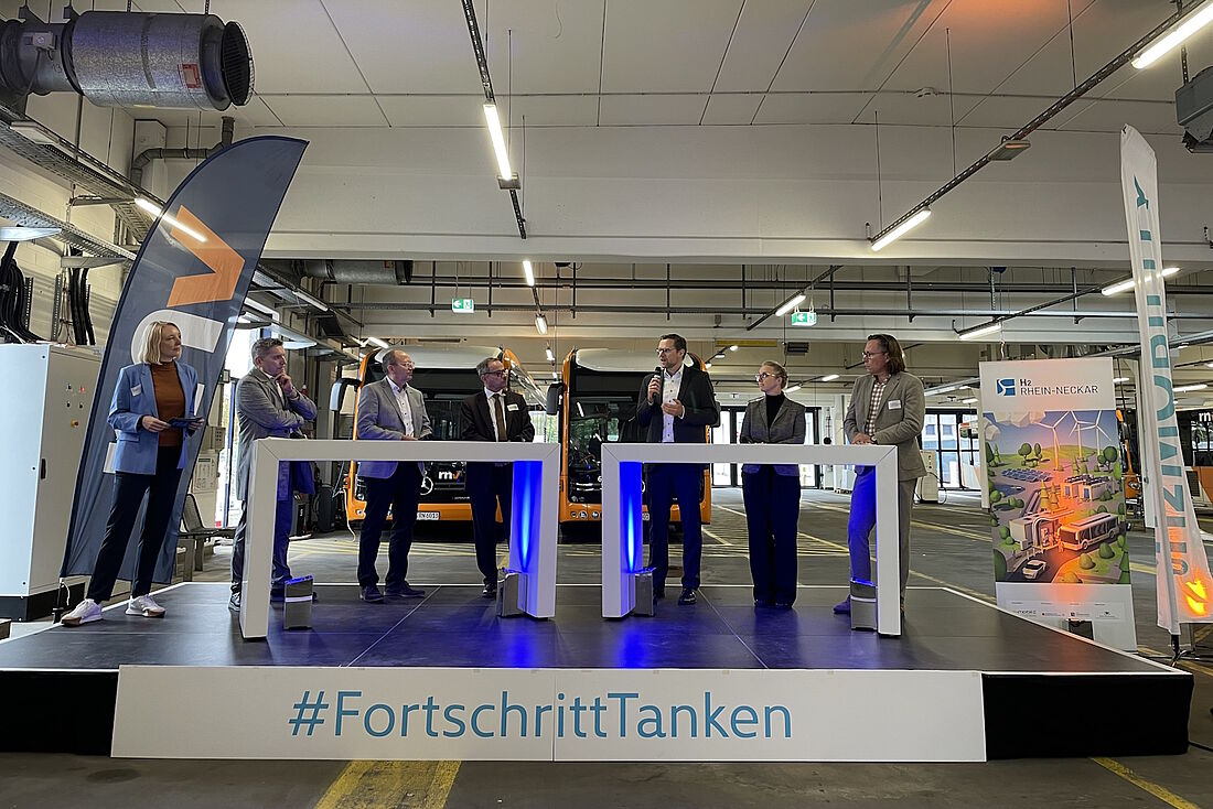 Verschiedene Redner stehen auf dem Podium zur Eröffnung der neuen H2-Tankstelle